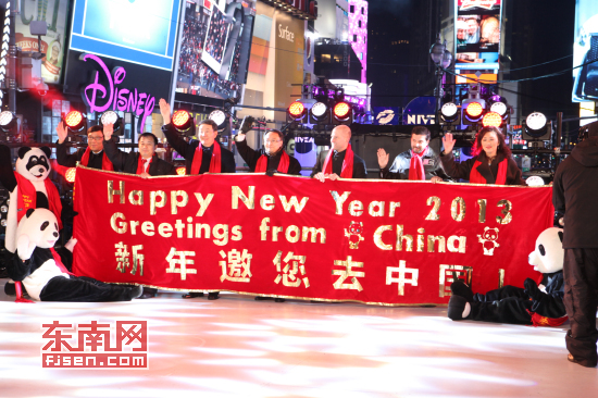 现场中美嘉宾们在时报广场主舞台拉起"新年邀您去中国"的红色横幅